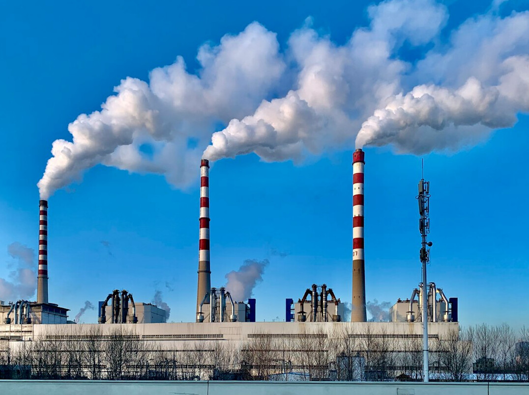 Industrial factory chimneys releasing smoke into the sky